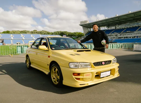 Yellow Subaru Impreza with its owner